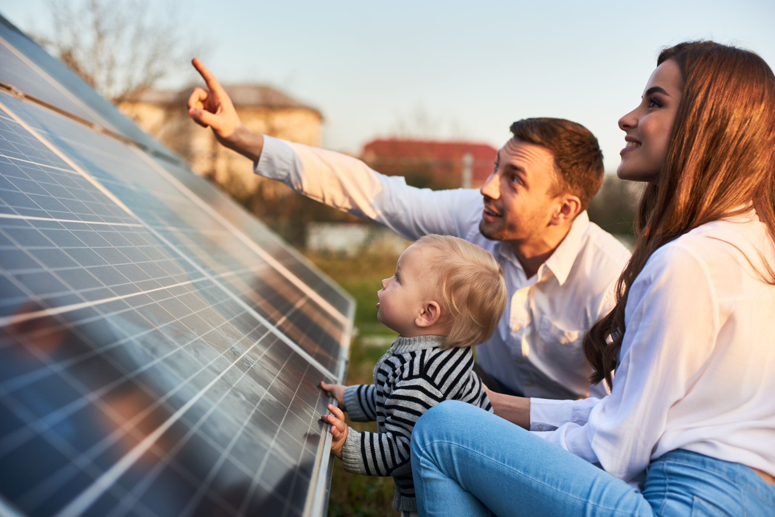 Mann, Frau und kleines Kind schauen sich eine Solarpanele an